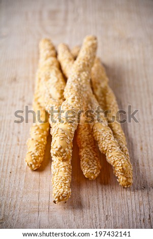 bread sticks grissini with sesame seeds on rustic wooden background