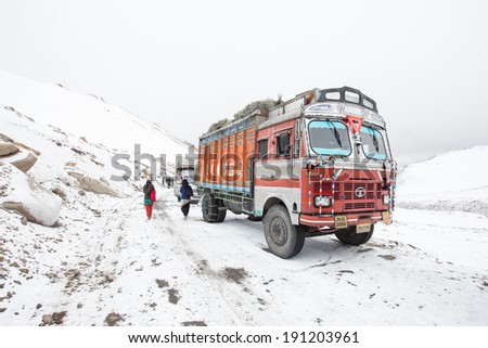 Ladakh, India - April, 17, 2014: Truck on the snow mountain and high altitude Khardung La Pass-Leh road, state of Ladakh, Indian Himalayas, India