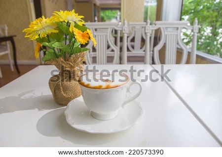 cup of coffee with flower  on table in cafe
