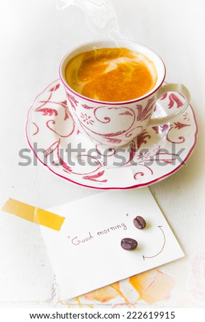 Coffee cup with smoke and good morning note on paper