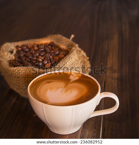Latte art coffee with coffee bean on wood table  vintage style