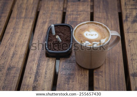 Latte Art coffee on wood table with ashtray