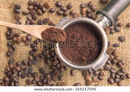 Filling coffee powder into port filter  with coffee bean background
