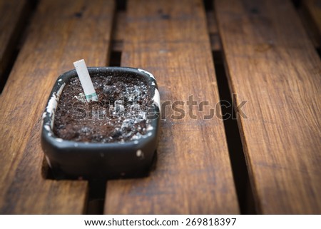 ashtray with smoke at wood table