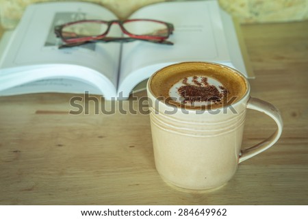 Cup of coffee with book and grass on table , vintage style image