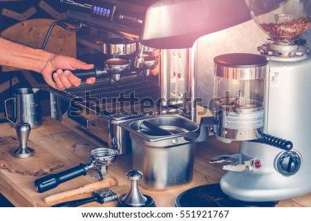 Hand of Barista put a portafilter to espresso machine for brewing coffee