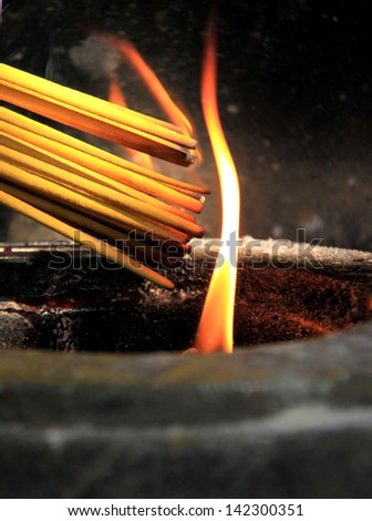 Prayers burning incense sticks on a temple fire