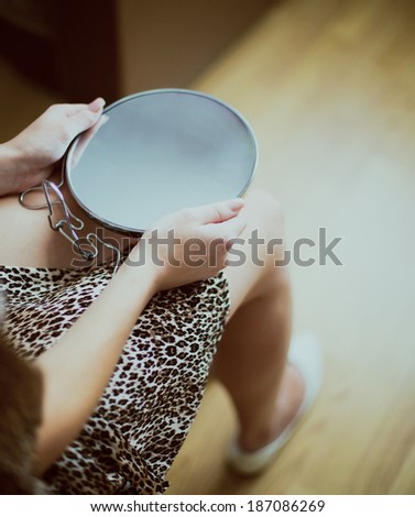 Girl holding a mirror in her hand