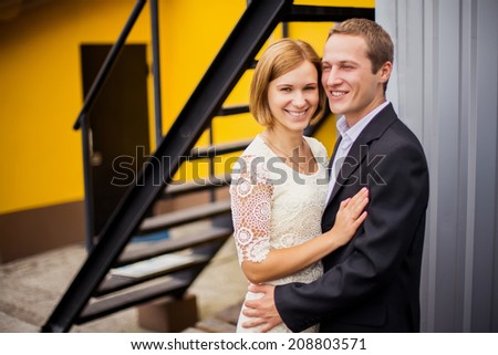 Happy bride and groom laughing and smiling on yellow background