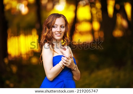 Young cheerful woman posing in autumn park