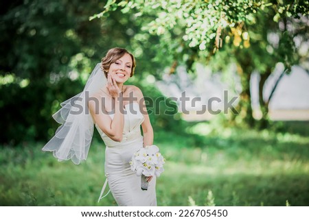 Beautiful young bride posing in summer. Wedding portrait