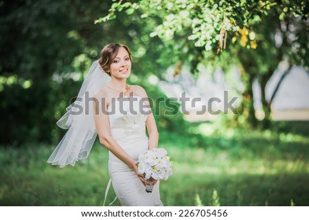 Beautiful young bride posing in summer. Wedding portrait