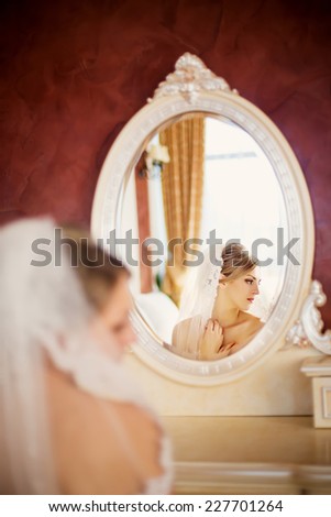 gentle bride looks in the mirror