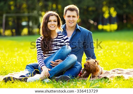 Lifestyle, happy family of two resting at a picnic in the park with a dog