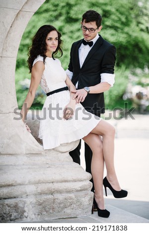 Emotional communication of lovely young couple by the stone relief.