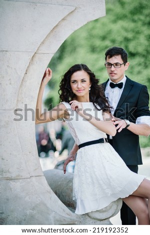 Emotional communication of lovely young couple by the stone relief.