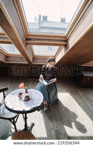 Young woman in cafe sitting and reading a book.