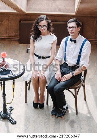Portrait of young couple in classic clothes. Modest poses.