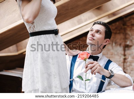 Couple flirting. Romantic moment: young man gives a rose to his girlfriend.