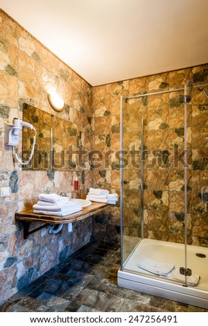 Interior of a modern bathroom. Shower cabin, basins, white towels. The vertical position photo.