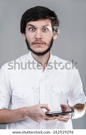 Young man giving a surprised look. Light background.