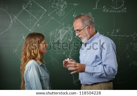Teacher talking with young student in the classroom
