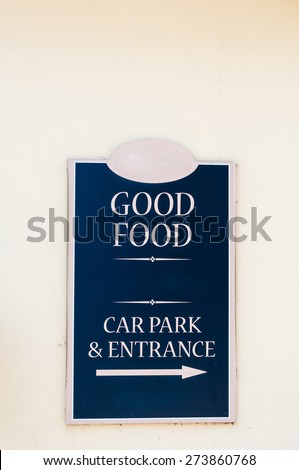 Restaurant sign advertising \'Good Food\' and sign for car park