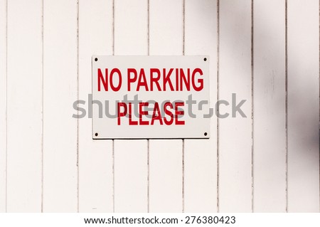 Polite warning Sign 'No Parking Please' mounted on a painted wooden surface
