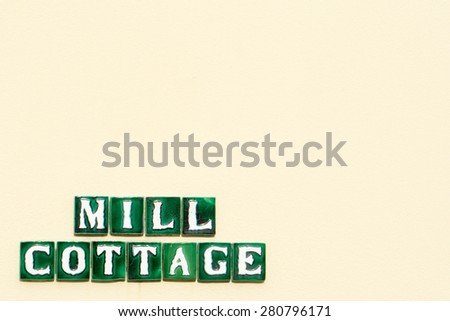 \'Mill Cottage\' text on a textured wall with empty space for your text