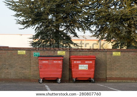 Large red Recycling Bins against a brick wall