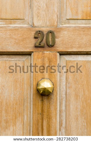 Number 20 twenty on a wooden door and knob textured  closeup