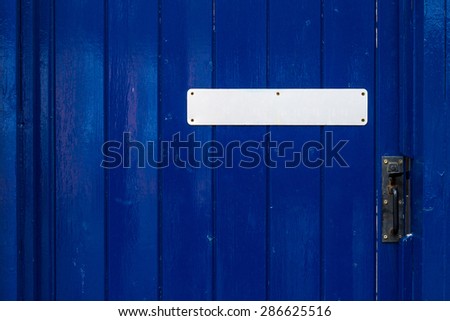 Blank plate on a old blue painted door  concept
