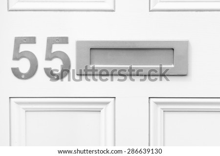 Door number 55 fifty five and letterbox monochrome conceptual image closeup