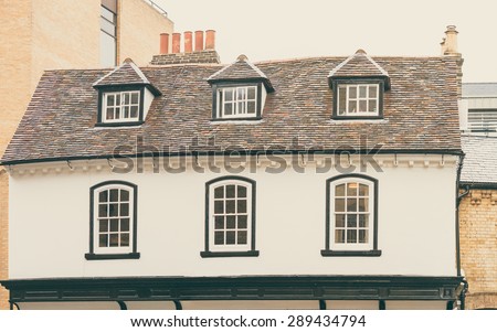 Traditional English timber cottage with loft conversion and chimneys in full view