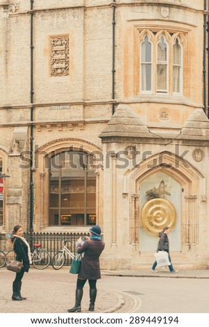CAMBRIDGE, ENGLAND - 7 MAY 2015: Tourist posing infront of John Taylor\'s Corpus Clock, which features an insect named Chronphage or \