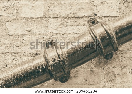 Weathered waste pipe attached on a wall conceptual image