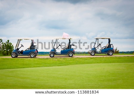 Three golf carts on green golf course