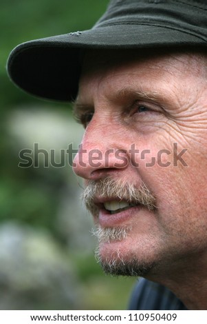 Head of man in green base ball cap