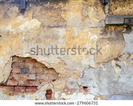 old textured wall worn out cement showing brick inside