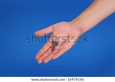 hand with metallic key on blue background.real estate theme.clipping path
