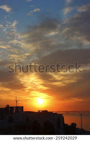 Early autumn morning, the sun rises over the buildings of the city