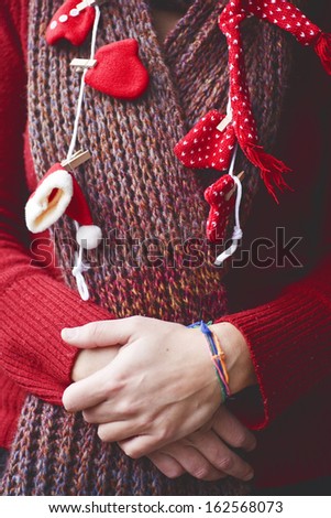 Christmas ornaments on a woman dressed in red wool