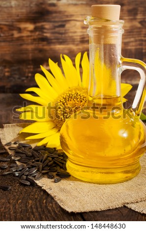 still life with vegetable oil in a glass bottle , and sunflower seeds