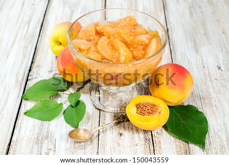 peach jam and fresh fruits with leaves on the wooden background