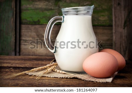 Baking ingredients : milk, eggs and wheat on wooden