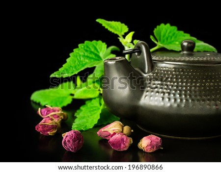 Chinese style tea with mint and dry roses on black
