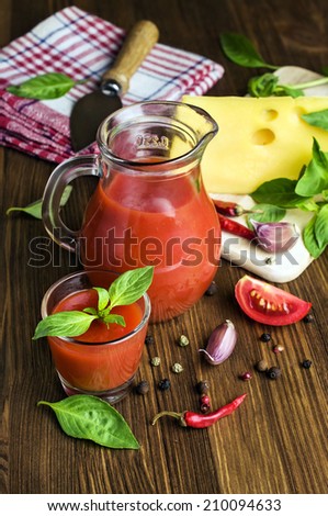 tomato juice with cheese, basil and spices on wooden table