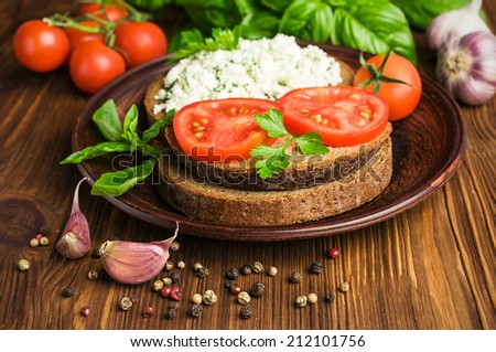 Sandwiches with rye bread, tomato, cheese and spices on wooden table