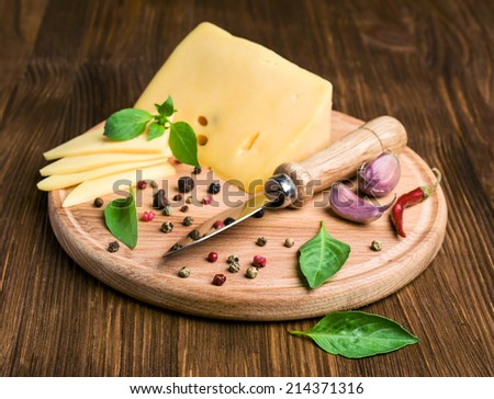 cheese, spices and a knife on a wooden background