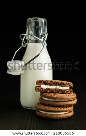 milk in a bottle with cocoa cookies on a dark background